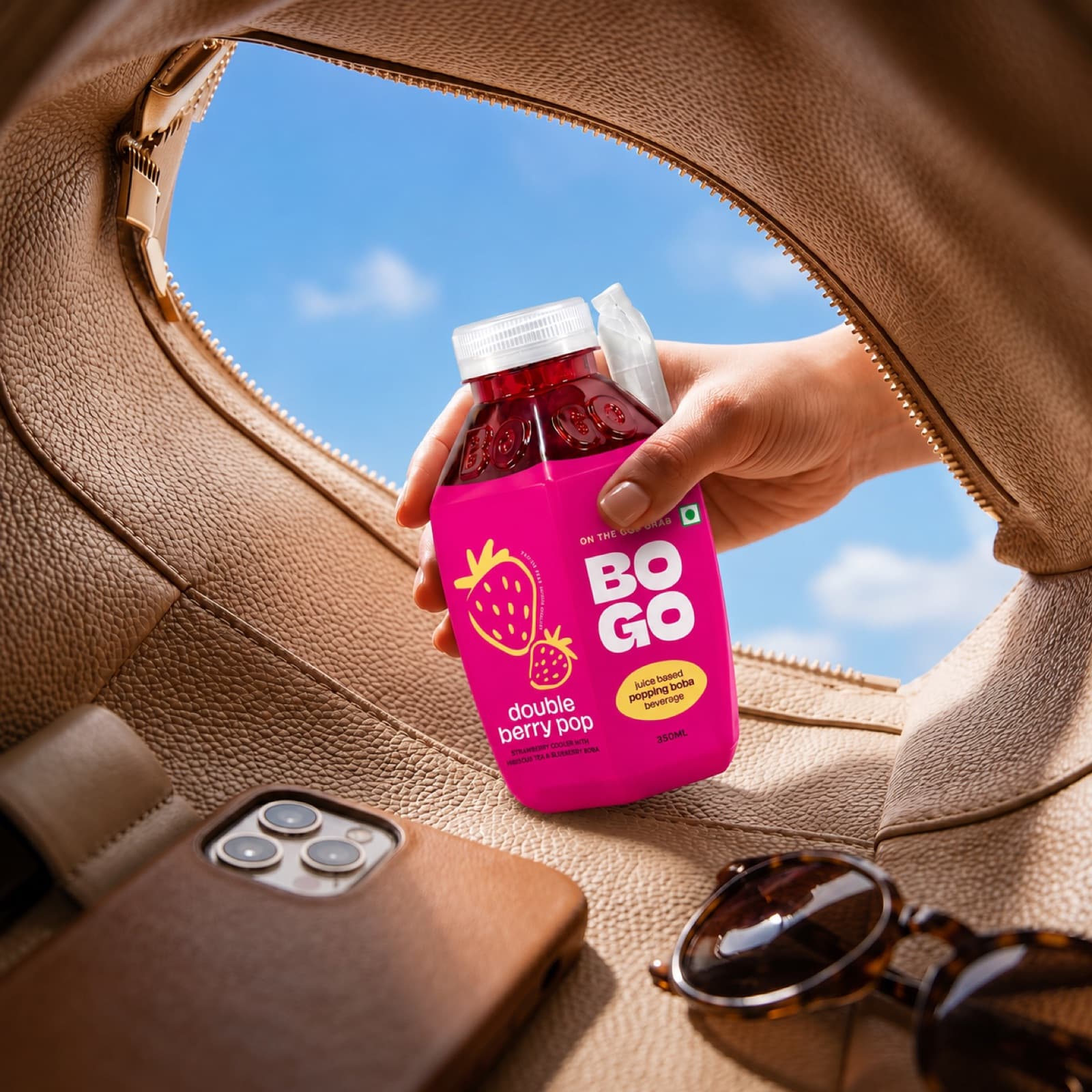 A hand grabbing a BOGO double berry pop from a bag, on the go